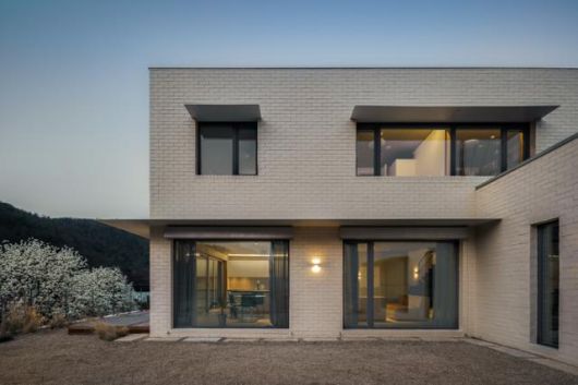 마당을 끼고 'ㄱ'자 형태로 세워진 주택. 심플한 철제 처마를 얹어 실용성을 더했다. 이재우 건축사진작가 제공