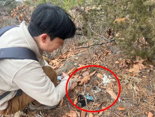 우동걸 연구원이 13일 서울 중랑구 면목동 용마산에서 산양 용마돌이의 배설물을 살펴보고 있다. 배설물 옆에는 산양이 파헤쳐놓은 것으로 보이는 담뱃값이 있었다. 고은경 기자