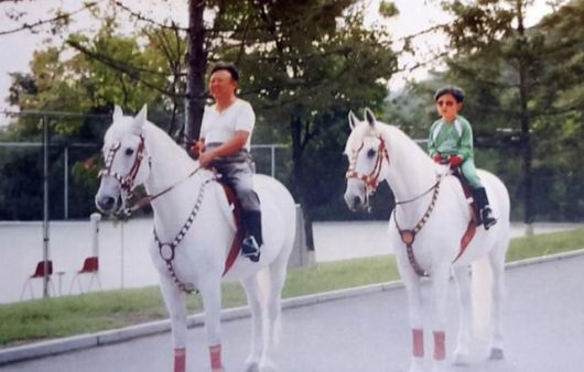 김정은 북한 국무위원장이 어린 시절 아버지 김정일 국방위원장과 평양 인근에서 승마를 즐기는 모습. 이 사진은 평양 인근의 한 혁명 사적관에 걸린 것으로 알려졌다. 연합뉴스