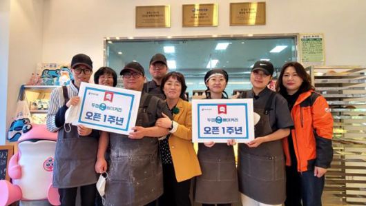 2022년 10월 광주동구지역자활센터 이수정(오른쪽 네 번째) 센터장이 청년들과 함께 두껍베이커리 1주년을 기념하고 있다. 하이트진로 제공