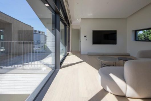 2층에서 바라본 거실 공간과 테라스. 4.5에 이르는 높은 천장고와 커다란 창, 거실과 연결된 나무 덱이 개방감을 선사한다. 김재윤 건축사진작가 제공