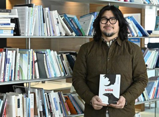 백영욱 작가가 서울 중구 한국일보 본사에서 본보와 인터뷰를 갖고 최근 출간한 '적색목록'을 들어 보이고 있다. 정다빈 기자