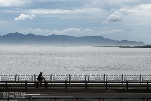 부네치아전망대 카페에서 보는 풍경. 여행객이 자전거로 해안도로를 달리고 있다.