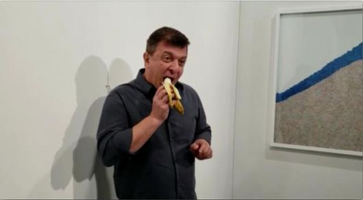 2019년 12월 7일 마이애미 비치에서 열린 국제 미술장터 '아트바젤 마이애미'에서 행위예술가인 데이비드 다투나가 이탈리아 예술가 마우리치오 카텔란의 작품 '코미디언'에 붙어 있던 바나나를 먹고 있다. 연합뉴스