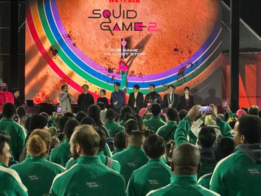 넷플릭스 '오징어 게임' 시리즈를 연출한 황동혁 감독과 이정재 등 오징어 게임 2 출연 배우들이 13일 미국 캘리포니아주 로스앤젤레스 시티칼리지에서 열린 오징어게임 팬이벤트에 참석해 참가자들에게 인사말을 하고 있다. 로스앤젤레스=이서희 특파원
