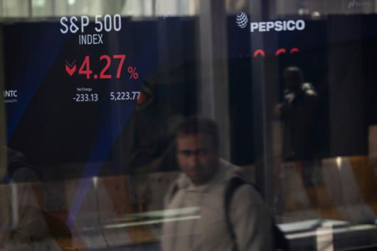 미국과 중국 간 '관세 전쟁' 여파로 뉴욕 증시가 폭락한 10일 한 남성이 뉴욕증권거래소 전광판 인근을 지나가고 있다. 뉴욕=AP 연합뉴스