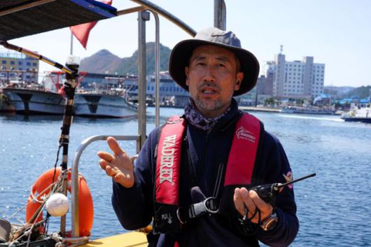 전대헌 한국해양구조대 영덕구조대장이 8일 경북 영덕군 축산항에 정박한 레저보트에서 지난달 말 산불 확산 때 주민들을 구하는 데 사용한 무전기를 들고 당시 상황을 설명하고 있다. 영덕=김정혜 기자