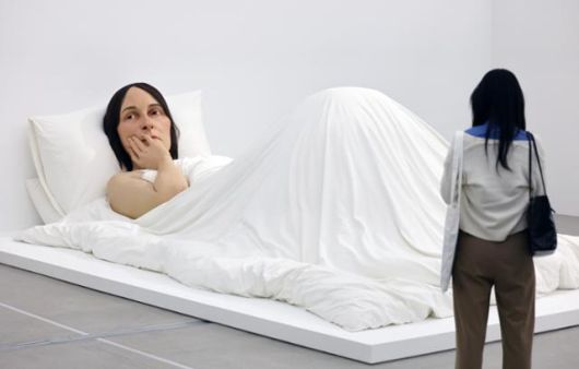 한 관람객이 론 뮤익의 조각 '침대에서'를 보고 있다. 뉴스1