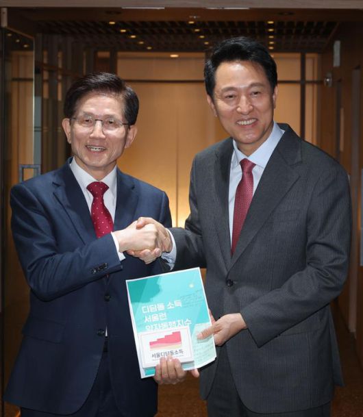 오세훈 서울시장과 회동을 마친 김문수(왼쪽) 전 고용노동부 장관이 16일 서울시청 시장실을 나서며 배웅 나온 오 시장과 악수하고 있다. 연합뉴스