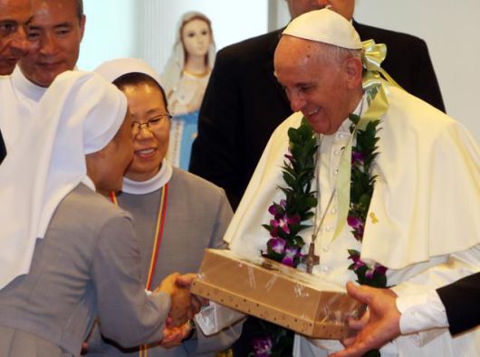 2014년 방한 당시 교황이 음성군 맹동면 꽃동네 희망의 집에서 수녀들이 준비한 선물을 전달받고 있다. 공동취재단