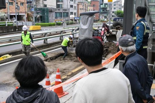 22일 서울 종로구 창신역 1번 출구 앞에 생긴 땅꺼짐으로 복구 작업이 이뤄지고 있다. 최주연 기자