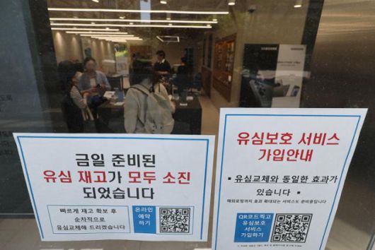 30일 서울 시내 한 SK텔레콤 인증 대리점에 유심 재고 소진과 유심보호 서비스 가입 안내문이 동시에 붙어있다. 연합뉴스