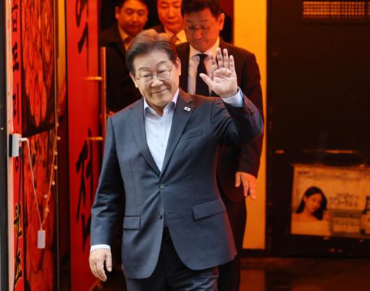 이재명 더불어민주당 대선 후보가 1일 서울 종로구의 한 포장마차에서 열린 비전형 노동자 간담회를 마치고 나오며 손을 들어 보이고 있다. 대법원 전원합의체는 이날 이 후보에게 무죄를 선고한 원심 판결을 파기하고 사건을 서울고법으로 돌려보냈다. 사진공동취재단