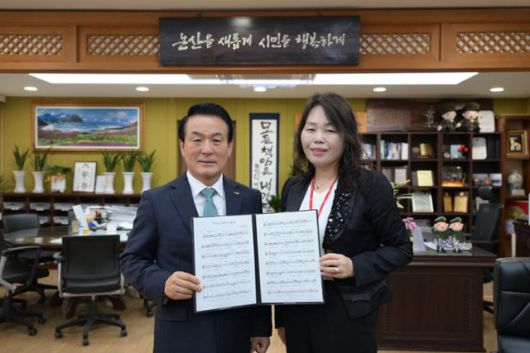 지난달 30일 만난 백성현(왼쪽) 충남 논산시장과 최영숙 논산시 아동돌봄과장이 세계 어린이날(11월 20일)을 맞아 유엔 아동권리송 지정을 추진하는 '우리는 모두 소중해' 악보를 보이며 취지를 설명했다. 논산시 제공