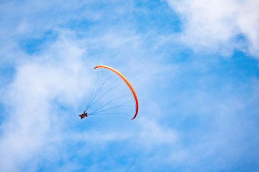 용문산 상공에서 한 패러글라이더가 거의 수직으로 기울어진 채 활공하고 있다.
