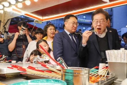 이재명(맨 오른쪽) 더불어민주당 대통령 후보가 2차 골목골목 경청투어에 나선 5일 오후 충북 진천군의 혁신도시 상가를 찾아 떡볶이를 먹고 있다. 진천=뉴스1