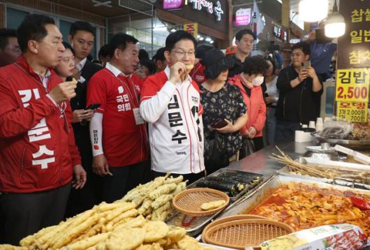 김문수 국민의힘 대선 후보가 13일 오후 울산 남구 신정시장을 찾아 튀김을 맛보고 있다. 울산=하상윤 기자