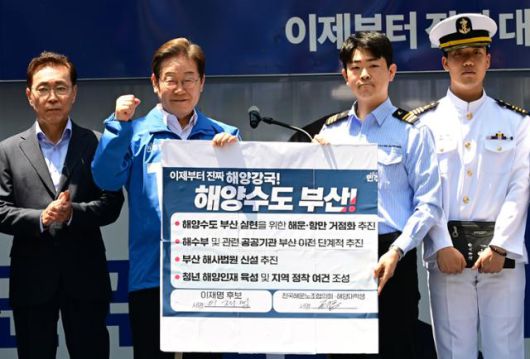 이재명 더불어민주당 대통령 후보가 14일 부산 부산진구 서면 젊음의 거리에서 권기흥 에이치라인해운해상직원노조 위원장과 해양수도 부산 협약서에 서명한 뒤 들어보이고 있다. 부산=고영권 기자