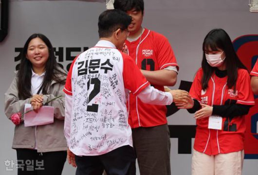 김문수 국민의힘 대선 후보가 19일 서울 중구 청계광장에서 청년들의 응원 메시지가 적힌 옷을 입고 청년들과 인사하고 있다. 하상윤 기자