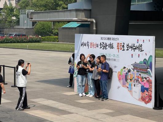 제21대 대통령 재외국민선거가 시작된 20일 중국에 거주하는 교민들이 투표소가 마련된 베이징 주중한국대사관에서 투표 인증샷을 찍고 있다. 베이징=이혜미 특파원