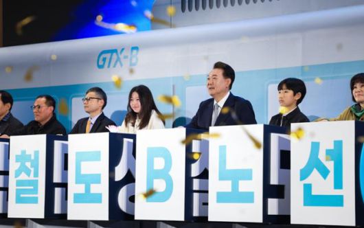 윤석열 대통령이 지난해 3월 7일 인천 송도컨벤시아에서 열린 수도권광역급행철도(GTX) B노선 착공기념식에서 지역주민들과 기념 세리머니를 하고 있다. 한국일보 자료사진