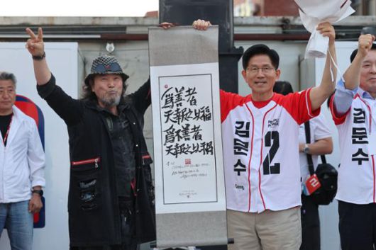 김문수 국민의힘 대선 후보가 25일 충남 서산시 중앙통 로데오거리에서 열린 집중유세에서 작가로부터 붓글씨를 선물받고 있다. 서산=뉴시스