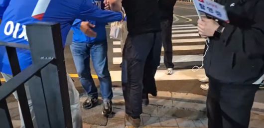 23일 부산 광안리에서 검은색 상의를 입은 한 청년(가운데)이 이재명 더불어민주당 대선 후보 지원 유세를 하고 있던 박주민(왼쪽) 민주당 의원을 어디론가 끌고 가려 하고 있다. '박주민TV' 유튜브 영상 캡처