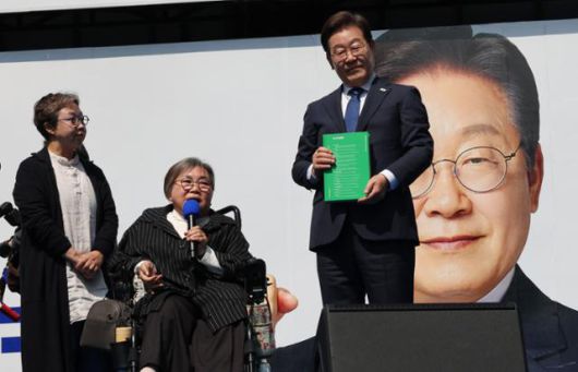 21대 대선 공식 선거운동이 시작된 지난 12일 이재명 더불어민주당 후보가 서울 청계광장에서 열린 '빛의 혁명' 광화문 유세에서 박김영희씨로부터 '모두의 질문 Q 녹서'를 전달받고 있다. 고영권 기자