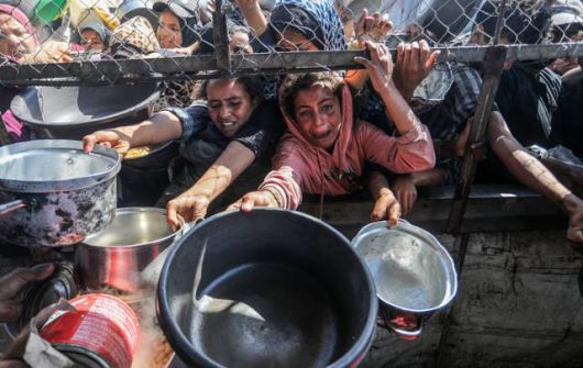 팔레스타인 주민들이 지난달 30일 가자지구 남부 도시 칸유니스의 피란민 캠프에서 구호품 배급을 받으려 몰려들어 있다. 칸유니스=UPI 연합뉴스