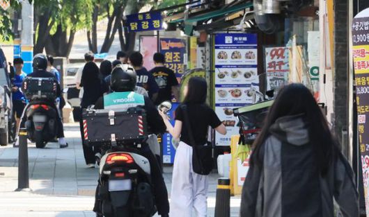 25일 서울 시내 한 음식점 앞에서 배달 라이더가 배달을 준비하고 있다. 연합뉴스