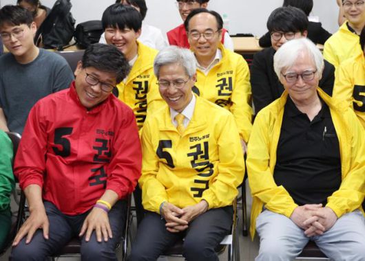 권영국(앞줄 가운데) 민주노동당 대선 후보가 3일 서울 구로구 민노당 당사에 마련된 선거캠프에서 제21대 대선 출구조사 결과를 지켜보며 미소 짓고 있다. 뉴시스