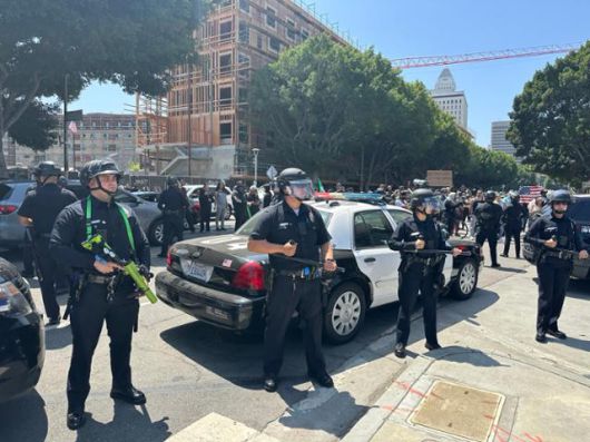 8일 미국 캘리포니아주 로스앤젤레스 메트로폴리탄 디텐션 센터 앞에서 비살상탄 발사기와 곤봉 등을 든 무장 경찰들이 도로를 막아서고 있다. 로스앤젤레스=이서희 특파원