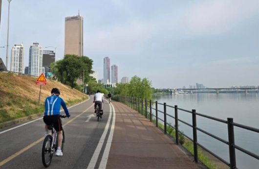 우원식(왼쪽 파란 슈트) 국회의장이 자전거를 타고 서울 여의도 63빌딩 방향으로 이동하고 있다. 우 의장 페이스북 캡처