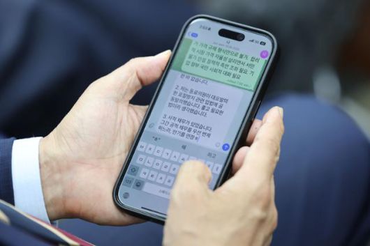 김민석 국무총리 후보자가 13일 서울 여의도 국회에서 열린 제2기 원내대표 선출 의원총회에 참석해 휴대폰으로 최근 의혹 관련 해명 글을 작성하고 있다. 뉴시스