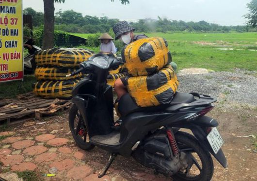 13일 베트남 하노이 닌히엡 시장 인근에서 한 상인이 정부 단속을 피해 물품을 옮기고 있다. 하노이=허경주 특파원