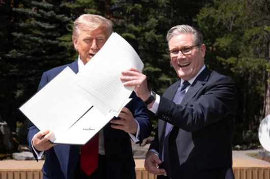 도널드 트럼프(왼쪽) 미국 대통령과 키어 스타머 영국 총리가 16일 캐나다 앨버타주 캐내내스키스에서 열린 주요 7개국(G7) 회의 도중 양국 간 무역협정 서명문을 들고 기념촬영을 하고 있다. 캐내내스키스=로이터 연합뉴스