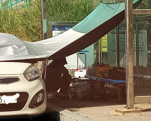 그늘막 밑 여성 앞에 해루질에 쓰이는 장비가 나열돼 있다. 보배드림 캡처