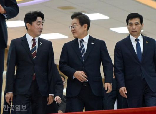 이재명(가운데) 대통령이 26일 서울 여의도 국회에서 추가경정예산안 시정연설을 마친 뒤, 강훈식(왼쪽) 비서실장과 대화하며 이동하고 있다. 고영권 기자