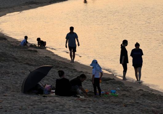 29일 강원도 강릉시 안목해변에서 시민들이 바닷물에 발을 담그거나 바닷바람을 맞으며 무더위를 식히고 있다. 강릉=연합뉴스