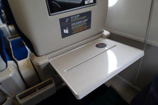 2세대 KTX-이음 좌석 앞 탁자가 스마트기기를 꽂을 수 있도록 가로로 움푹 패인 공간이 있다. 주머니형 무선 스마트폰 충전기도 설치돼 있다. 현대로템 제공