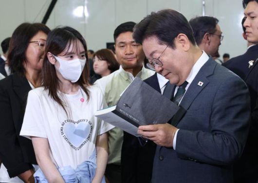 이재명 대통령이 4일 대전 유성구 대전컨벤션센터에서 열린 국민소통 행보, 충청의 마음을 듣다 '충청의 꿈 다시 키우다'를 마치고 퇴장하며 한 참석자가 가져온 책에 사인을 해주고 있다. 왕태석 선임기자