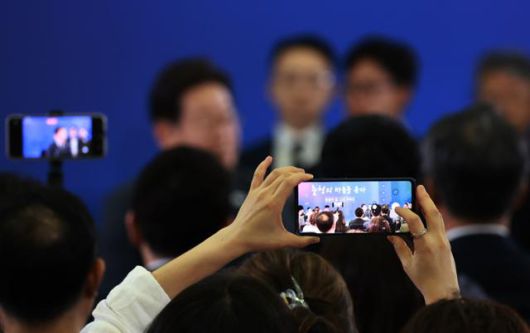 4일 대전컨벤션센터에서 타운홀 미팅 형식으로 열린 이재명 대통령의 '국민소통 행보 2탄, 충청의 마음을 듣다'에 참석한 한 시민이 휴대폰에 간담회 모습을 담고 있다. 연합뉴스