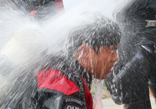 6일 인천 계양구 병방동 맨홀 내부서 실종자 수색작업을 하고 나온 119구조대원이 소방호스로 더위를 식히고 있다. 연합뉴스