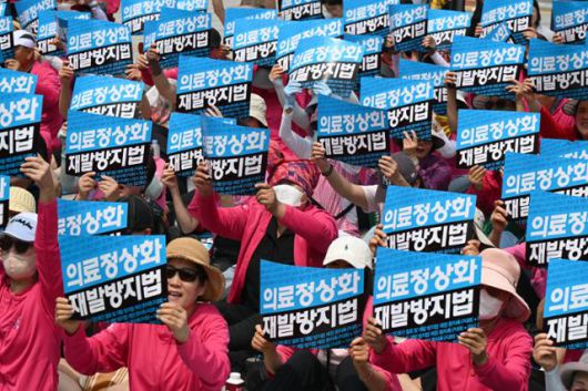 지난해 7월 4일 서울 종로구 보신각 앞에서 102개 환자단체가 참여한 '의사 집단휴진 철회 및 재발 방지법 제정 촉구' 집회가 열린 가운데 참가자들이 손팻말을 들고 구호를 외치고 있다. 한국일보 자료사진