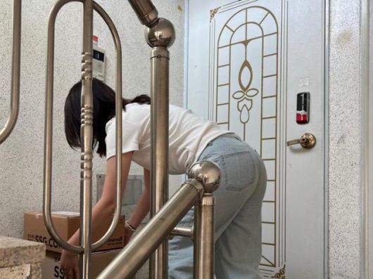 12일 본보 권정현 기자가 서울 화곡동의 한 빌라 계단을 택배 상자를 들고 올라가고 있다. 택배기사 신씨가 촬영해 준 사진이다. 권정현 기자