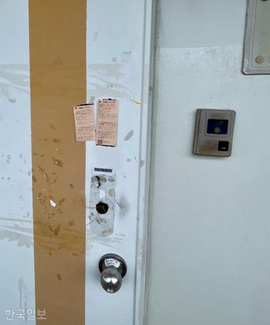 사망한 지 3주 만에 시신으로 발견된 모자가 살았던 대전 서구 관저동의 한 아파트 출입문에 14일 우편물 도착안내서가 붙어 있다. 이날 집 주변에서는 여전히 악취가 진동하고 있었다. 대전=정민승 기자