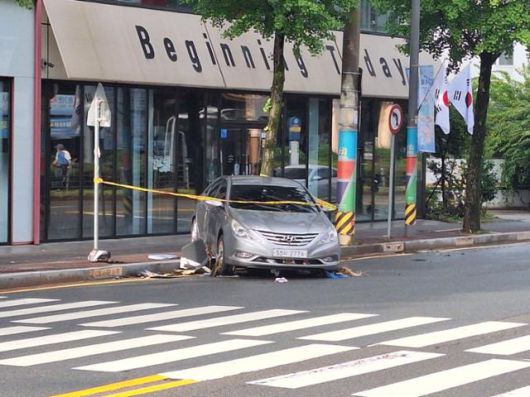 18일 오전 광주 북구 용봉동의 한 상가 앞 보도 턱에 전날 극한 호우에 휩쓸려 떠내려온 승용차가 절반쯤 걸쳐 있다.
