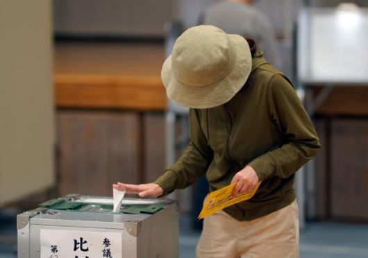 한 일본 여성이 참의원 선거가 실시된 20일 투표소장인 도쿄 도내 학교 체육관에서 투표함에 투표 용지를 넣고 있다. 도쿄=EPA 연합뉴스