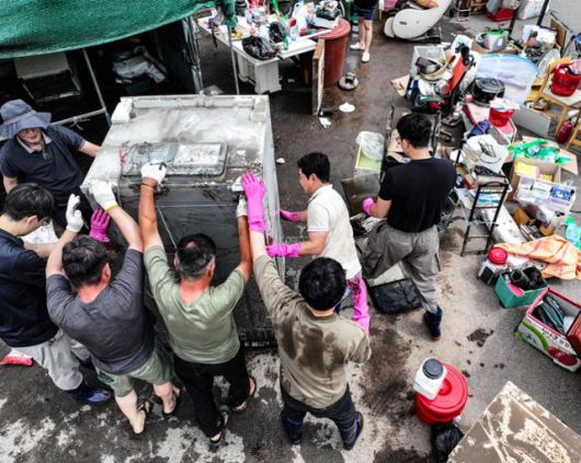 18일 전날 내린 폭우로 침수 피해를 입은 대구 북구 노곡동 한 가정집에서 주민과 공무원들이 복구 작업을 하고 있다. 대구=연합뉴스