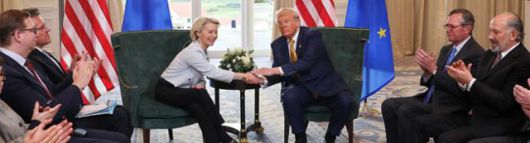 도널드 트럼프 대통령이 27일 영국 스코틀랜드 턴베리에서 미국과 유럽연합(EU) 간의 무역 협의를 발표한 뒤 우르줄라 폰 데어라이엔 EU집행위원장과 악수하고 있다. 오른쪽에 하워드 러트닉 상무부 장관이 박수를 치고 있다. 턴베리=로이터 연합뉴스